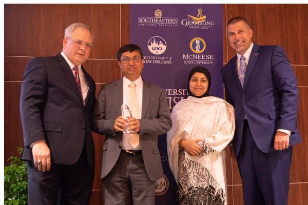 University of Louisiana System President Jim Henderson presents the outstanding faculty award to TK体育 finance professor M. Kabir Hassan, who is joined by his wife, Dr. Tahmina Hassan, MD and President John Nicklow.  The award was presented during the annual For Our Future Conference held at UL Lafayette.