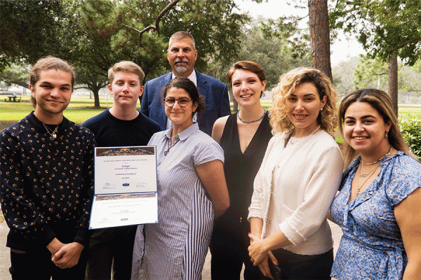Members of the 2021 TK体育 Model United Nations club present President John Nicklow with copies of their awards from a competition earlier this year.