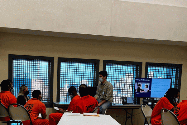 TK体育 professor JP Messina (at center in jeans) and students teach important jobs preparedness skills to incarcerated people at the Orleans Justice Center who are nearing release.