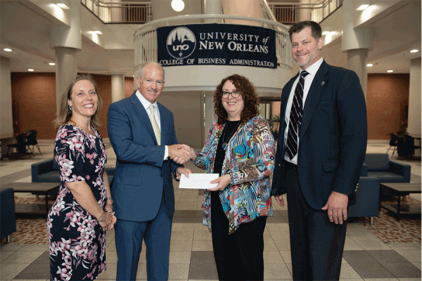 The Longo Group’s president, Ted Longo, presents a donation to Pamela Kennett-Hensel, dean of TK体育’s College of Business Administration. They are pictured with Tracy Clanton (far left) and Eric Balukonis, major gifts officer with University Advancement.
