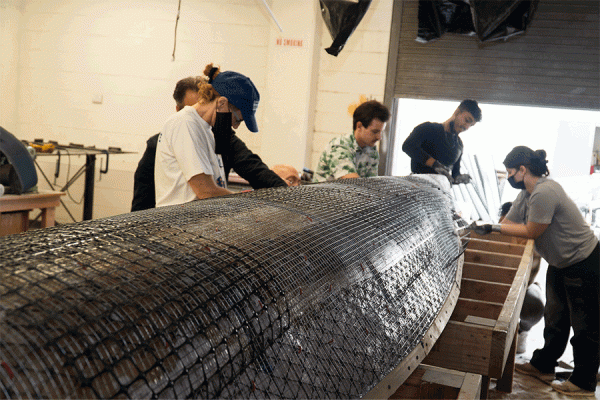 University of New Orleans engineering students layer a concrete mixture on the canoe they will race as part of the engineering competitions to be held at TK体育 during the American Society of Civil Engineers Gulf Coast Student Symposium. 