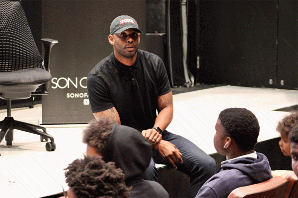 Former New Orleans Saints wide receiver Marques Colston, a research fellow with TK体育’s Urban Entrepreneurship and Policy Institute, talks with students during a financial literacy class. 